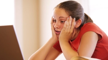 Girl feel boring reading content on laptop