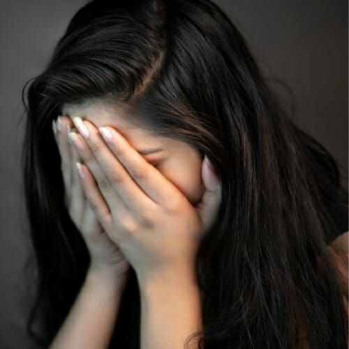 sad girl crying hiding face